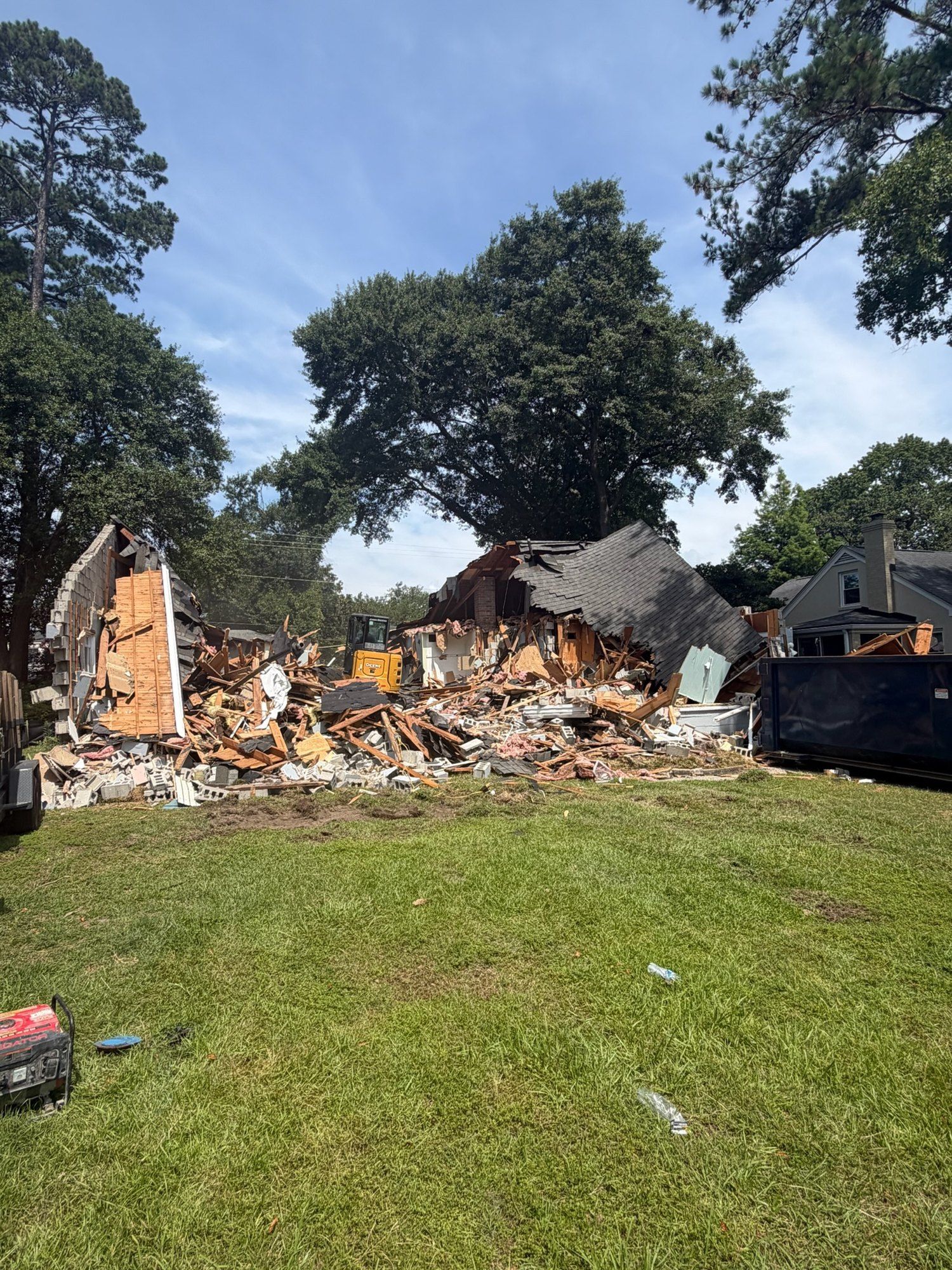 Demolition of the original house with an excavator on site