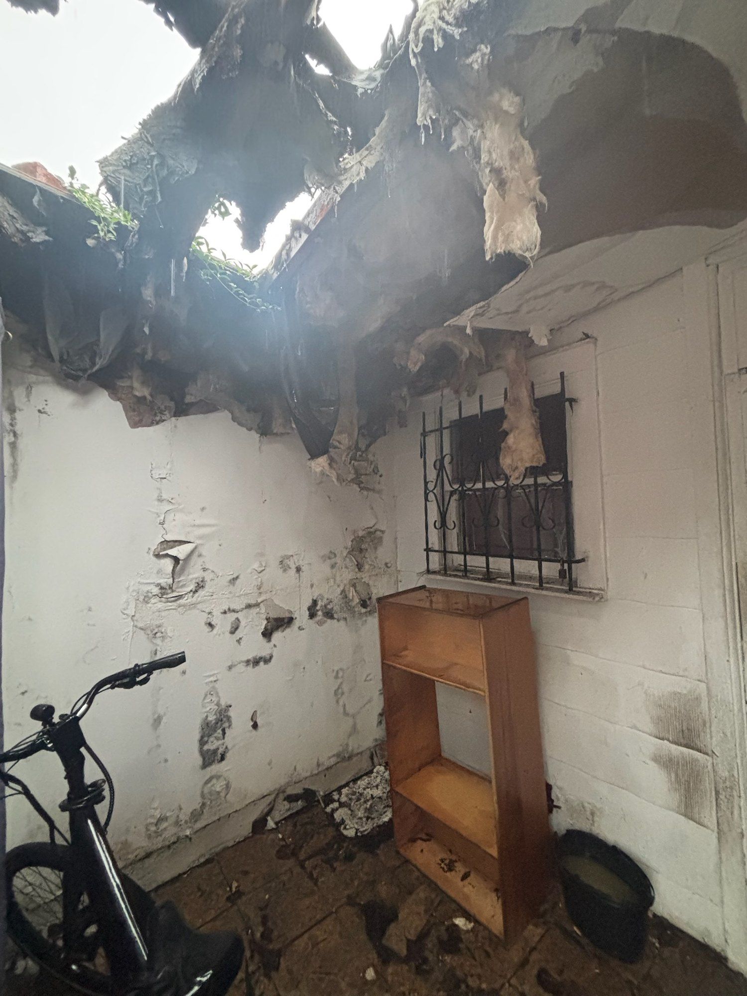 Damaged ceiling open to the sky before renovation