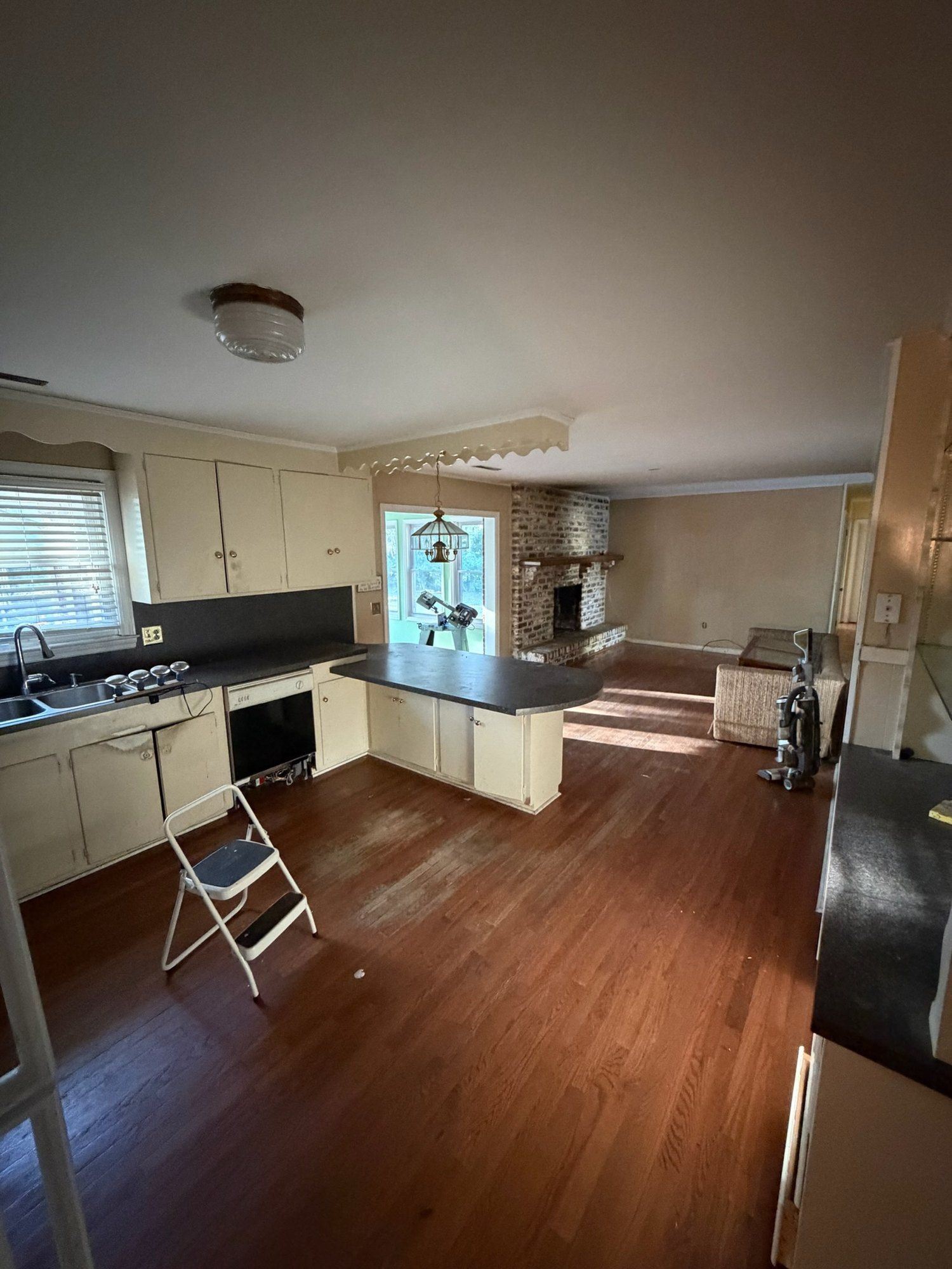 Original kitchen and family room with dated cabinets and laminate counters