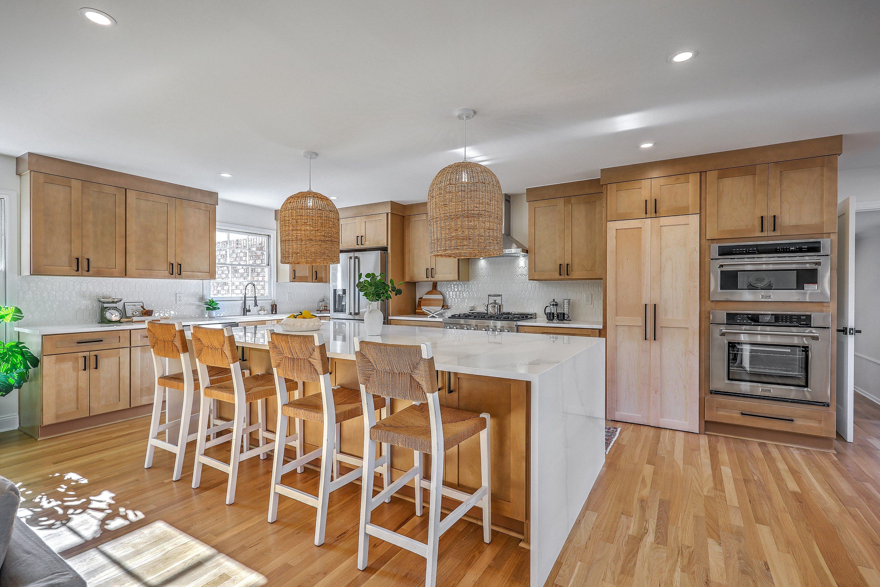 Chef's kitchen with natural wood cabinetry, waterfall island, woven pendants and ZLINE appliances