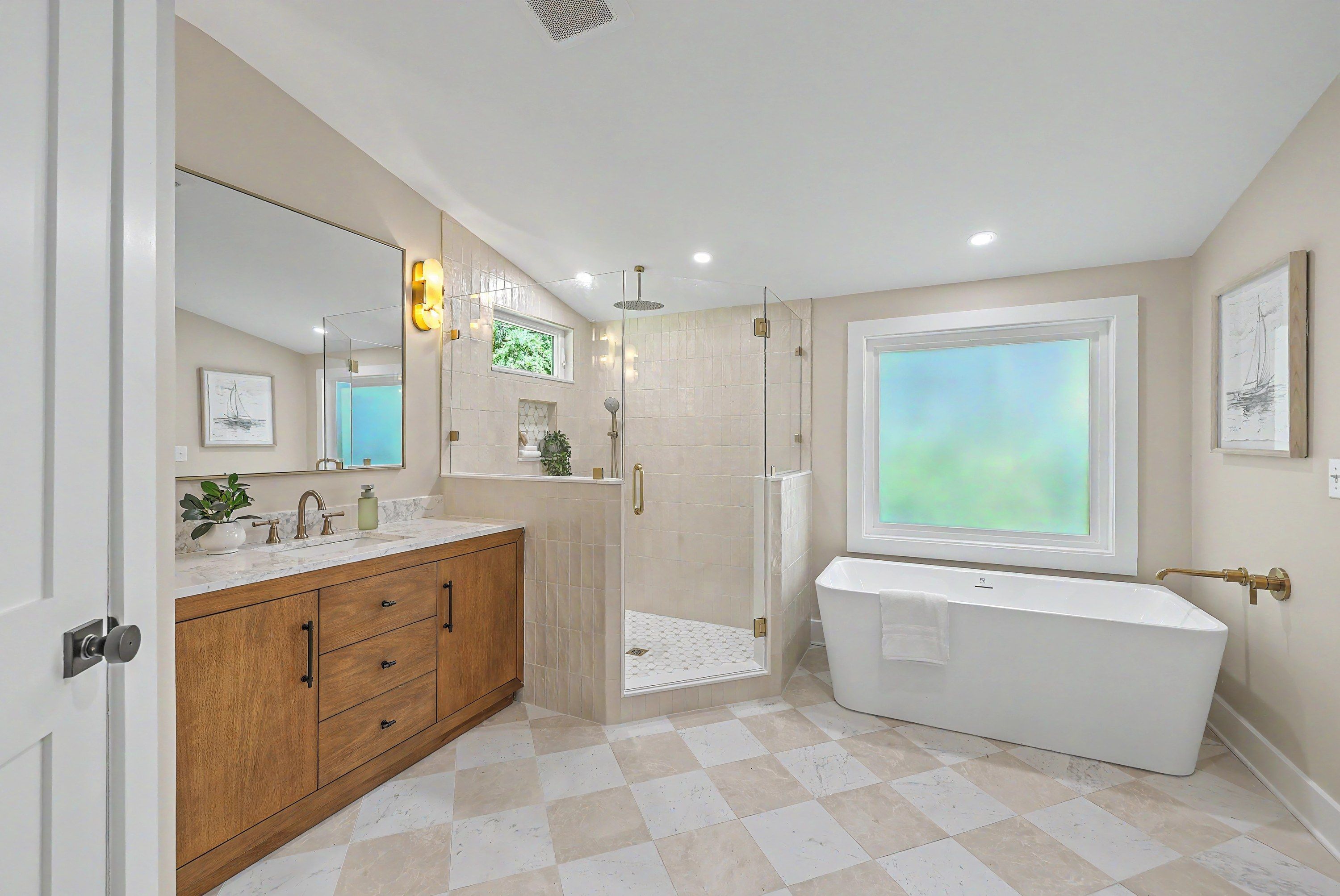 Primary bath in the new addition with freestanding tub, tiled shower and wood vanity