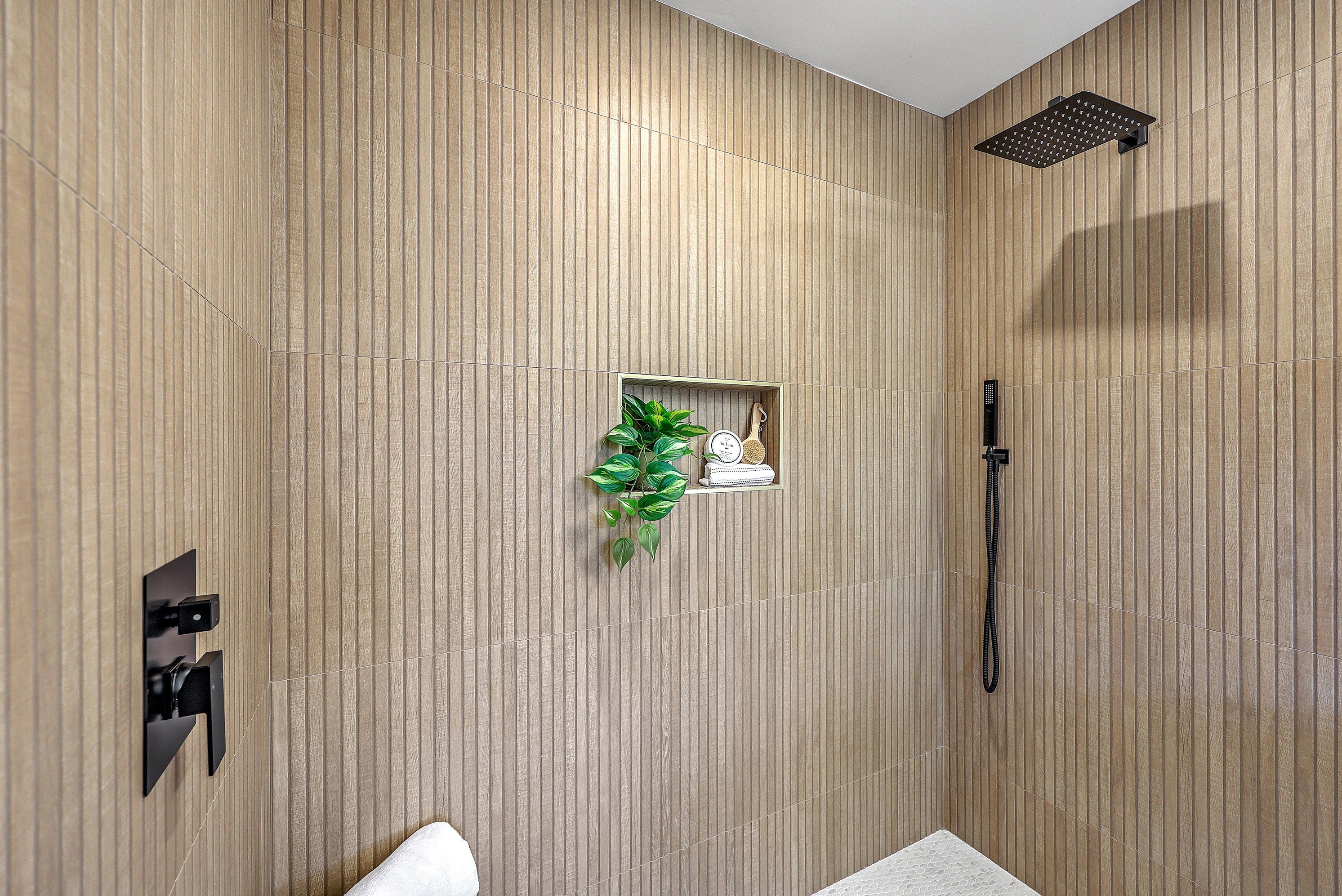 Spa-inspired shower with fluted wood-look tile and matte black fixtures